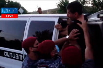 Police officers apprehend protesters near Governmental house